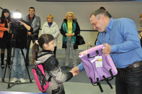 Сергей Ефанов вручает портфели детям украинских переселенцев